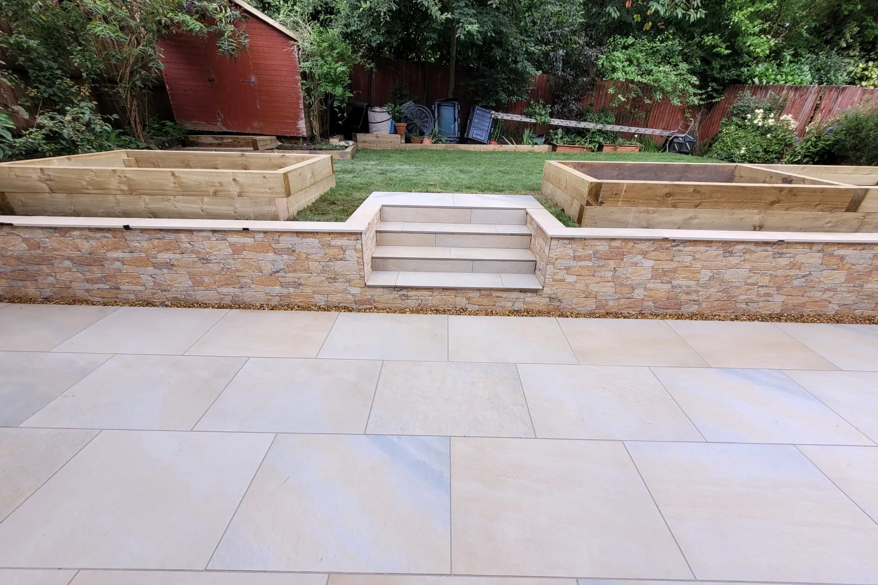Tiered garden with porcelain steps, stone walls and raised beds
